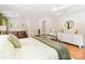 Comfortable bedroom featuring a bed, a leather sofa, wooden floors, and a white dresser with a circular mirror at 1505 Clarendon Pl, Rock Hill, SC 29732