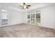 Spacious main bedroom featuring neutral carpet, ceiling fan, and multiple windows for natural light at 19509 Trintella Ln, Cornelius, NC 28031