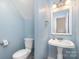 Powder room with blue walls features a pedestal sink and toilet at 19509 Trintella Ln, Cornelius, NC 28031