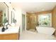 Bright bathroom featuring double vanity, soaking tub, and glass enclosed shower at 21514 Gulfstar Ct, Cornelius, NC 28031