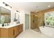 Bright bathroom featuring double vanity, soaking tub, and glass enclosed shower at 21514 Gulfstar Ct, Cornelius, NC 28031