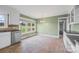 Eat-in kitchen featuring stainless dishwasher, white cabinetry, and green accent wall at 2178 Tryon Courthouse Rd, Bessemer City, NC 28016