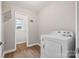 Bright laundry room leading into a bathroom with a washing machine at 2178 Tryon Courthouse Rd, Bessemer City, NC 28016