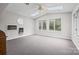 Bright living room features skylights, a ceiling fan, three large windows, and neutral carpet at 2178 Tryon Courthouse Rd, Bessemer City, NC 28016