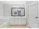 Bright bathroom with dual sinks, a bathtub, a large mirror, and neutral color palette at 2527 Fossil Stone Ln, Fort Mill, SC 29708
