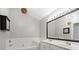 Well-lit bathroom featuring dual sinks, a bathtub, a large mirror, and contemporary fixtures at 2527 Fossil Stone Ln, Fort Mill, SC 29708