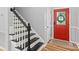 Stylish entryway featuring a staircase with contrasting black and white elements and a red front door at 2527 Fossil Stone Ln, Fort Mill, SC 29708