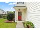 Welcoming front entrance with a vibrant red door, decorative wreath, and well-kept landscaping at 2527 Fossil Stone Ln, Fort Mill, SC 29708