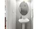 Charming powder room with a pedestal sink, oval mirror, and neutral tones at 2527 Fossil Stone Ln, Fort Mill, SC 29708