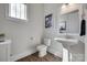Well-lit powder room with wood floors, pedestal sink, and a large picture at 264 Auburn View Rd, Rock Hill, SC 29730
