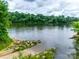 Scenic river view with a concrete boat ramp, rocky shoreline, and lush green trees in the background on a cloudy day at 264 Auburn View Rd, Rock Hill, SC 29730
