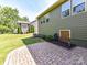 Landscaped backyard features a stone paver patio and verdant lawn surrounded by mature trees at 2972 Arches Bluff Cir, Lancaster, SC 29720