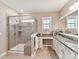 A relaxing bathroom featuring a glass-enclosed shower, granite countertop, and ample natural light from the window at 2972 Arches Bluff Cir, Lancaster, SC 29720