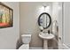 Cozy half bathroom with pedestal sink, decorative mirror, and tiled floors that adds a touch of elegance to the home at 2972 Arches Bluff Cir, Lancaster, SC 29720