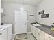 Bright laundry room with modern washer/dryer, utility sink, and granite countertops, blending functionality with style at 2972 Arches Bluff Cir, Lancaster, SC 29720