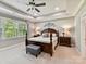Serene bedroom featuring a dark wood four-poster bed, neutral colors, and tray ceiling at 2972 Arches Bluff Cir, Lancaster, SC 29720