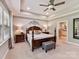Spacious main bedroom featuring tray ceiling, four-poster bed, and a glimpse into the luxurious en-suite bathroom at 2972 Arches Bluff Cir, Lancaster, SC 29720