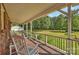 A serene back porch with rocking chairs overlooks the property's expansive, well-maintained lawn and lush landscaping at 321 York Southern Rd, Fort Mill, SC 29715
