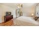 Bedroom with hardwood floors, ceiling fan, large window, and dresser with television at 321 York Southern Rd, Fort Mill, SC 29715