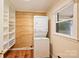 Functional laundry room featuring stacked washer and dryer, built-in shelving and wood paneled accent wall at 321 York Southern Rd, Fort Mill, SC 29715
