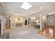 Open concept living room featuring carpet, a skylight and an adjacent room beyond an opening at 321 York Southern Rd, Fort Mill, SC 29715