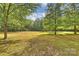Expansive lawn featuring large shade trees is ideal for recreational activities and enjoying the natural surroundings at 321 York Southern Rd, Fort Mill, SC 29715