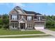 Charming two-story home with a mix of stone and brick, accented by dark shutters and a well-manicured lawn at 324 Coronado Ave, Matthews, NC 28104