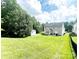 Expansive backyard featuring a lush lawn, storage shed, and patio area surrounded by mature trees at 4048 Cascade Dr, Gastonia, NC 28056