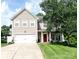 Charming two-story home featuring a red front door, well-manicured lawn, and a two-car garage at 4048 Cascade Dr, Gastonia, NC 28056