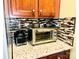 Close-up of a kitchen countertop with a toaster oven, Ninja blender and stylish backsplash and granite countertops at 4048 Cascade Dr, Gastonia, NC 28056