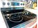 Close-up of a sleek, modern black glass cooktop with multiple burners and stainless steel trim at 4048 Cascade Dr, Gastonia, NC 28056