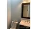 Powder room features a single sink vanity, framed mirror and toilet at 419 W 8Th St, Newton, NC 28658
