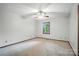 Bedroom with neutral carpet, a ceiling fan, and a window overlooking the wooded backyard at 4323 Crow Rd, Monroe, NC 28112