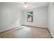 Bedroom with neutral carpet, a ceiling fan, and a window overlooking the wooded backyard at 4323 Crow Rd, Monroe, NC 28112