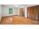 A large bedroom with hardwood floors, a ceiling fan, and a closet with wooden doors at 4323 Crow Rd, Monroe, NC 28112