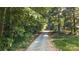 Gravel driveway approaching the house, lined with lush trees and greenery at 4323 Crow Rd, Monroe, NC 28112