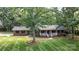 Attractive brick home featuring a well-kept lawn with mature trees and inviting covered porch at 4323 Crow Rd, Monroe, NC 28112