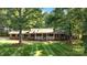 Charming brick home featuring a well-manicured lawn and covered porch nestled among mature trees at 4323 Crow Rd, Monroe, NC 28112
