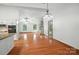 Open-concept living room with hardwood floors and a fireplace extending into kitchen at 4323 Crow Rd, Monroe, NC 28112