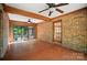 Relax in the sunroom with brick floors, wood beams, and ample light from surrounding windows and glass doors at 4323 Crow Rd, Monroe, NC 28112