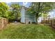 Spacious backyard featuring a patio area, green lawn, flower bed and wood fence at 501 Mercury St, Charlotte, NC 28205