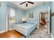 Cozy bedroom features a white frame bed with wood floors, natural light and a glimpse into another room at 501 Mercury St, Charlotte, NC 28205