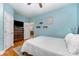 Comfortable bedroom features wood floors, blue walls, dresser, and a doorway to another room at 501 Mercury St, Charlotte, NC 28205