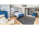 Large bedroom with a blue frame bed, wood floors, large windows, a ceiling fan and a sitting area at 501 Mercury St, Charlotte, NC 28205