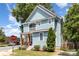 A lovely two-story light blue home with porch and upper level balcony on a tree-lined street at 501 Mercury St, Charlotte, NC 28205
