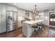 Modern kitchen features stainless steel appliances, an island with seating, and grey cabinets at 5701 Cedar Hill Dr, Monroe, NC 28110