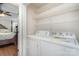 Laundry room with washer, dryer, and wire shelving with bedroom visible through the door at 5701 Cedar Hill Dr, Monroe, NC 28110