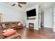 Cozy living room with hardwood floors, fireplace, built-in shelving, and large leather sofa at 5701 Cedar Hill Dr, Monroe, NC 28110