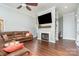 Cozy living room with hardwood floors, fireplace, built-in shelving, and large leather sofa at 5701 Cedar Hill Dr, Monroe, NC 28110