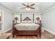 A spacious main bedroom featuring a four-poster bed, ceiling fan, and hardwood floors at 5701 Cedar Hill Dr, Monroe, NC 28110